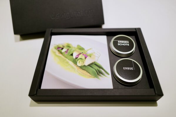 Verpackungsdesign: Die Essigbrätlein Kochbox als tiefschwarzer, blindgeprägter Schuber mit Rezeptkarte und fermentierten Zutaten in feinen Metalldöschen.